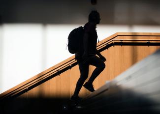 Silhouette of student walking up stairs